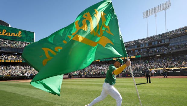 OAKLAND, CALIFORNIA - SEPTEMBER 26: Max Schuemann #12 of the Oakland Athletics runs with a Oakland Athletics flag after they beat the Texas Rangers at the Oakland Coliseum on September 26, 2024 in Oakland, California. Today will be the final Athletics game played at the Coliseum. (Photo by Ezra Shaw/Getty Images)